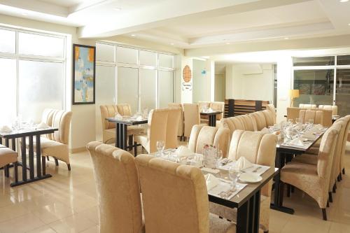 a dining room with tables and chairs in a restaurant at Falettis Express Islamabad in Islamabad