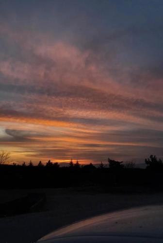 a sunset in the sky over a road at סוויטת לורד הרמיטאז' בגולן in Bruchim Qela' Alon