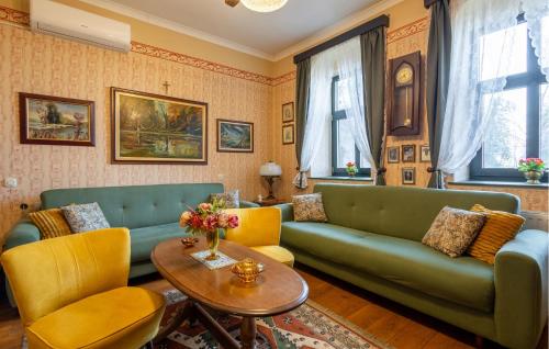 a living room with a green couch and yellow chairs at 2 Bedroom Amazing Home In Draz in Draž