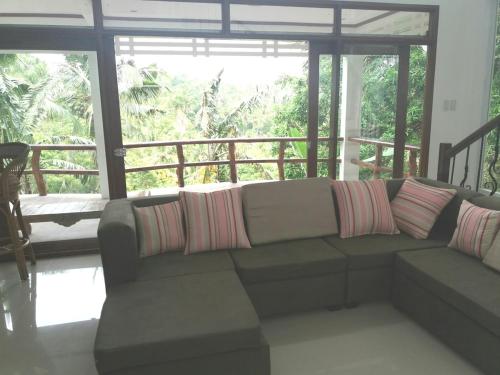 a living room with a couch with pillows on it at Puerto Galera Hilltop Guesthouse -Tropical Retreat in Puerto Galera