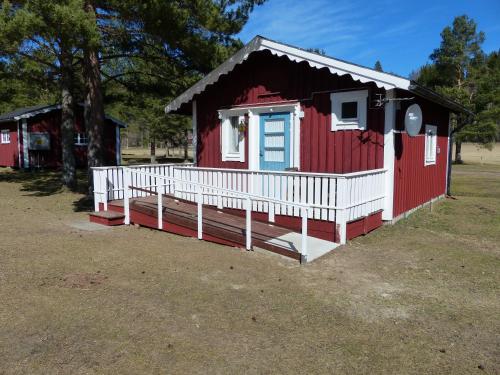 a red and white house with a white porch at Björkebo Camping in Stöllet