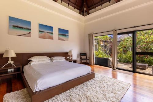 a bedroom with a bed and a large window at Villa Serenity Cove by IHR in Bel Ombre