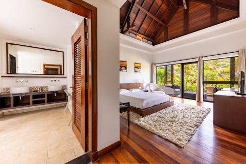 a bedroom in a villa with a bed and a bathroom at Villa Serenity Cove by IHR in Bel Ombre