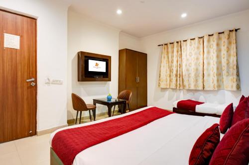 a hotel room with a bed and a television at Hotel Chanakya Inn in New Delhi