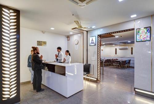 a group of people standing at a reception counter at Hotel Chanakya Inn in New Delhi