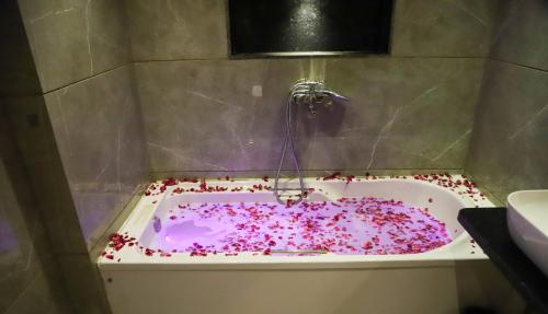 a bath tub covered in pink sprinkles in a bathroom at Hotel Aura Inn Airoli ,Digha in Navi Mumbai