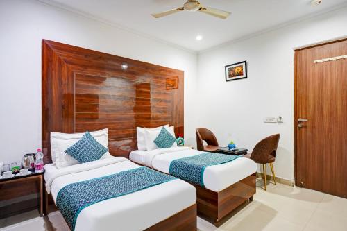 a hotel room with two beds and a desk at Hotel Chanakya Inn in New Delhi