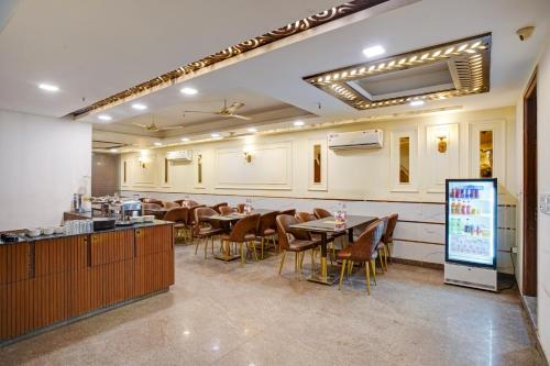 a restaurant with tables and chairs in a room at Hotel Chanakya Inn in New Delhi