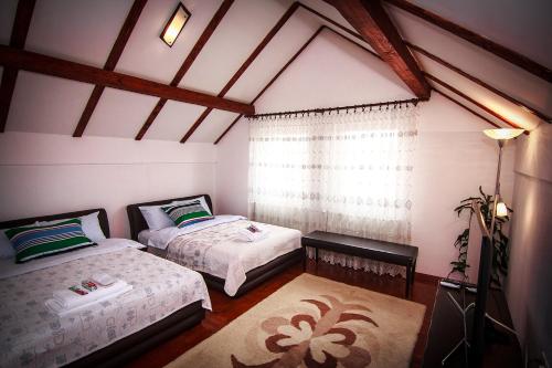 1 dormitorio con 2 camas y ventana en Apartment Red House, en Visoko