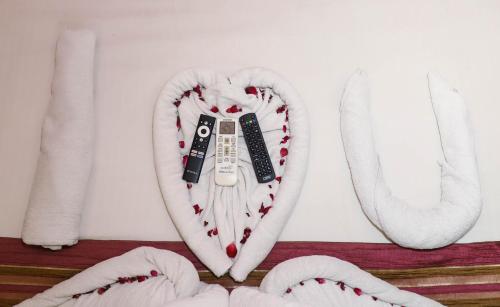 a heart shaped pillow with a remote control in it at Hotel Aura Inn Airoli ,Digha in Navi Mumbai