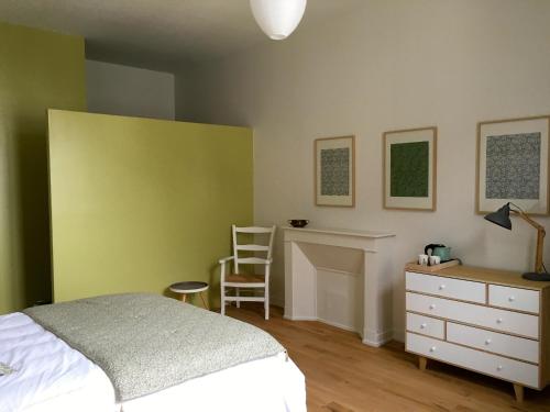 a bedroom with a bed and a desk and a chair at La Maison Saint Aignan in Saint-Aignan