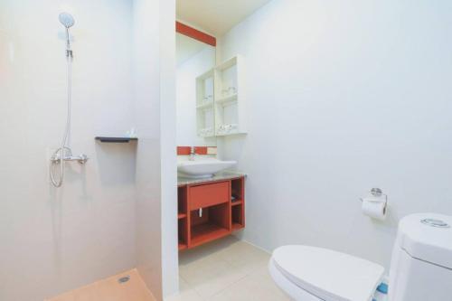 une salle de bain avec des toilettes blanches et un lavabo dans l'établissement Apartments Near Bangtao Muay Thai & MMA, à Ban Thalat Choeng Thale