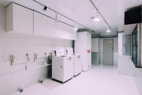 a room with white appliances and sinks and a television at Minimalist Loft 4 Namba Compact Studio and Gym MA405 in Osaka