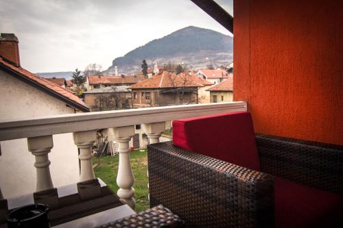 a balcony with a chair and a view of a city at Apartment Red House in Visoko