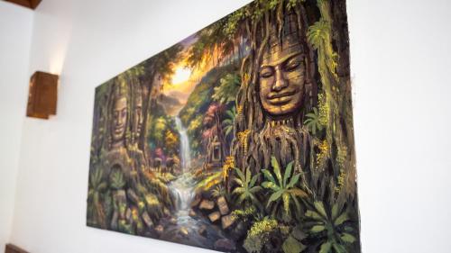 a painting of a statue in the jungle at Khmer Lodge - Eco-Lodge in Phumĭ Réach Born