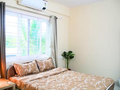 una camera con un letto con finestra e una pianta di Evara Kondapur Retreat Luxury 3BHK fully Equipped Apt a Hyderabad