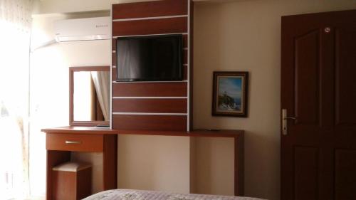 a bedroom with a dresser with a mirror and a tv at Gelibolu Hotel in Gelibolu