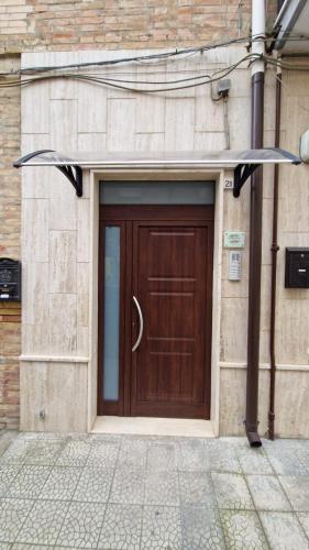 a brown door on the side of a building at Giù da nonna in Lucera