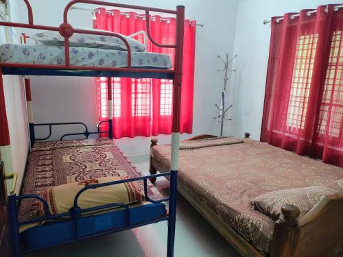 two bunk beds in a room with red curtains at 3 bedroom country home with a lush full backyard in Trichūr