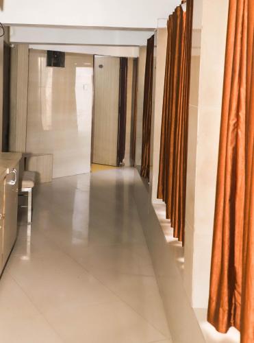 a hallway with orange curtains and a long corridor at Maharashtra Guest House in Kalyan