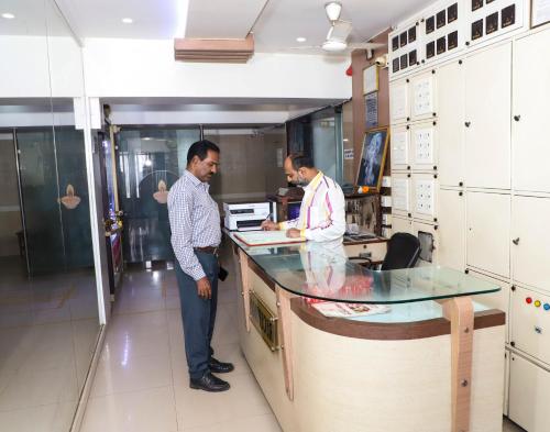 two men standing at a counter in a kitchen at Maharashtra Guest House in Kalyan