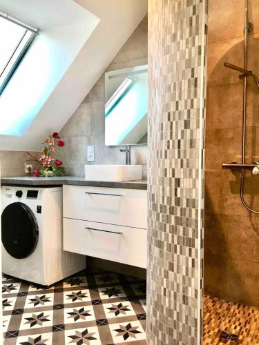 une salle de bain avec un lavabo et une machine à laver dans l'établissement APPARTEMENT NEUF 4 personnes A SAINT BRIAC SUR MER, à Saint-Briac-sur-Mer