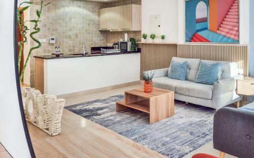 a living room with a couch and a table at Cozy Golfside Studio in Abu Dhabi