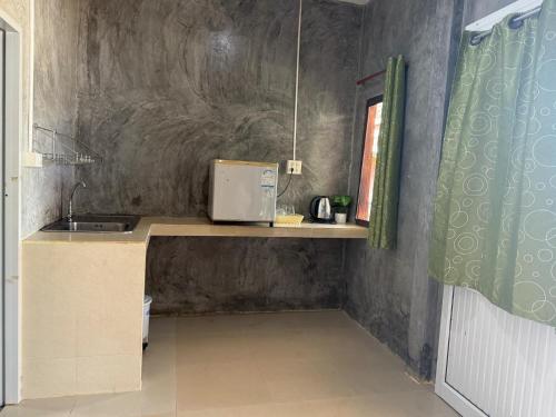 eine Küche mit einer Theke mit Spüle und einem Fenster in der Unterkunft Lanta natural hut garden in Phra Ae beach