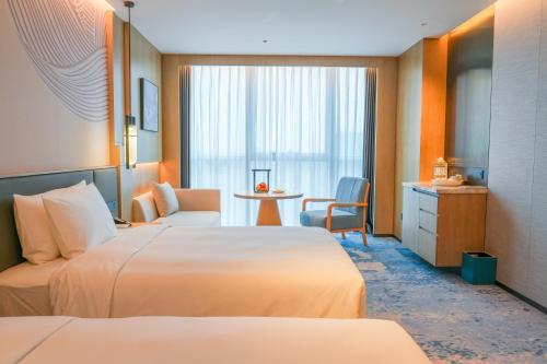 a hotel room with two beds and a table at Wyndham Hotel Guangzhou Huangbian Metro Branch - Free shuttle bus to Canton Fair in Guangzhou