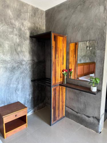 a bathroom with a mirror and a wooden shelf at Lanta natural hut garden in Ko Lanta