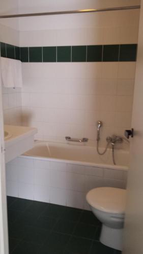 ein Badezimmer mit einer Badewanne, einem WC und einem Waschbecken in der Unterkunft Hobbit Hotel Zaventem in Zaventem