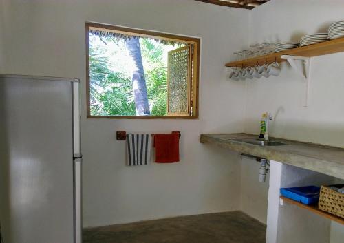a kitchen with a refrigerator and a window at King's Beach Cottage in Mambrui