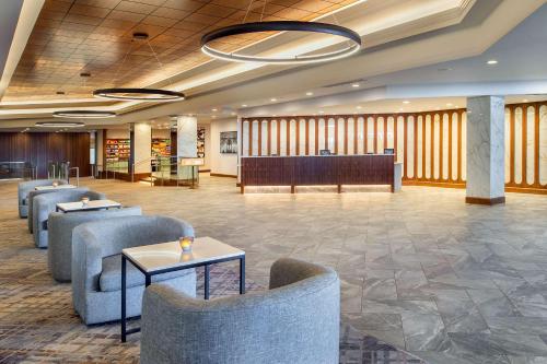 a lobby with chairs and a waiting room at Hilton St. Louis Airport in Woodson Terrace