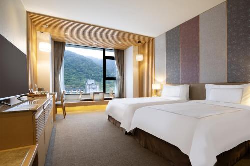 Postel nebo postele na pokoji v ubytování Evergreen Resort Hotel - Jiaosi