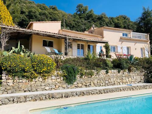 une maison avec un mur en pierre à côté d'une piscine dans l'établissement Maison de charme avec vue mer et piscine sur les hauteurs de Nice, à Aspremont