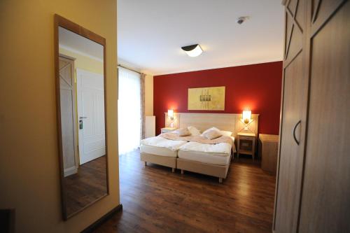 a bedroom with a bed with red walls and a mirror at Dreimädelhaus - Kirchseelte in Kirchseelte