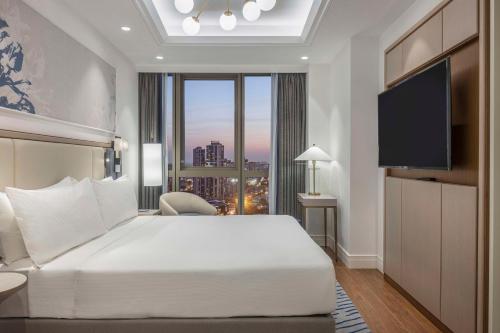 a bedroom with a large white bed and a large window at Hilton Mall Of Istanbul in Istanbul