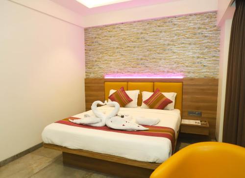 a bedroom with a bed with two swans on it at Hotel Aura Inn Airoli ,Digha in Navi Mumbai