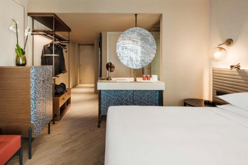a bedroom with a bed and a desk and a mirror at Hyatt Centric Malta in St. Julianʼs