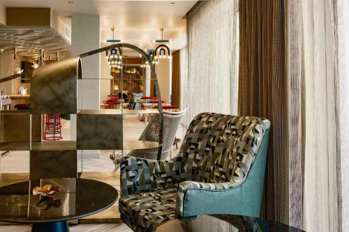 a living room with a chair and a table at Hyatt Centric Malta in St. Julianʼs
