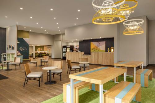 a waiting area with tables and chairs in a cafeteria at Spark By Hilton Nashville At Opryland in Nashville