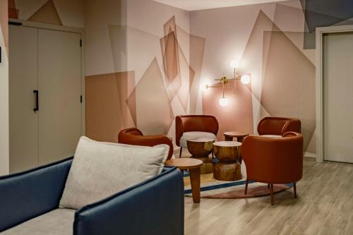 a waiting room with a couch and chairs and a table at Hyatt Centric Malta in St. Julianʼs
