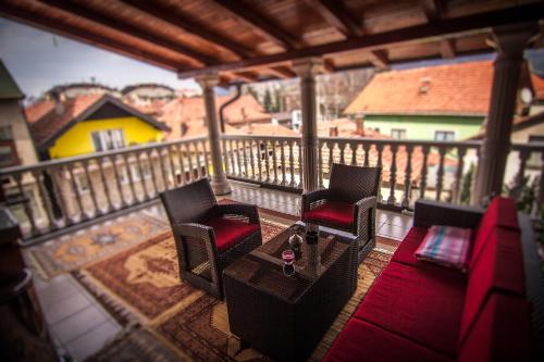 a porch with two chairs and a table on a balcony at Apartment Red House in Visoko