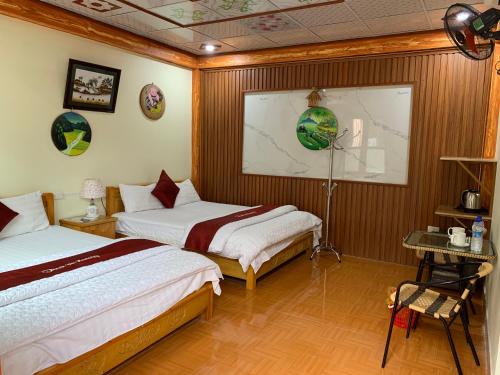 una habitación de hotel con dos camas y una mesa en Tam Coc Thanh Dat Homestay, en Ninh Binh