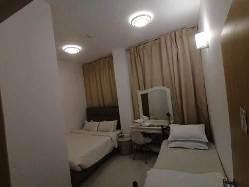 a small room with two beds and a mirror at International City CBD 2 in Dubai