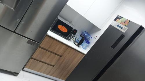 a kitchen with a black refrigerator and a wooden door at International City CBD 2 in Dubai