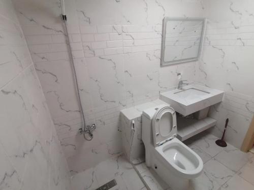a white bathroom with a sink and a toilet at International City CBD 2 in Dubai