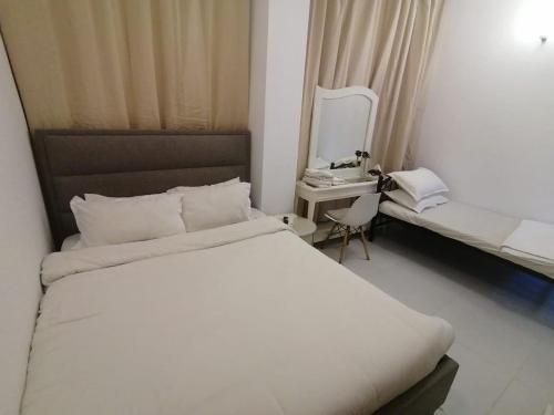a bedroom with a white bed and a mirror at International City CBD 2 in Dubai