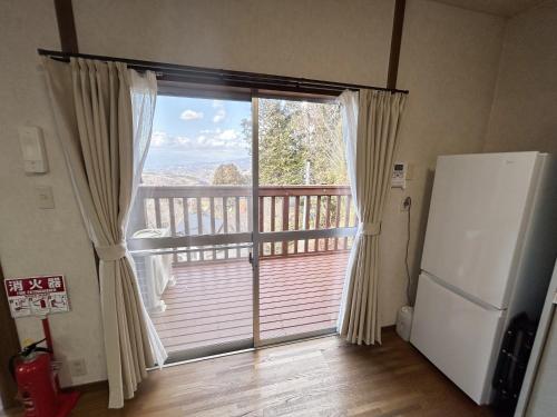 a kitchen with a large window and a refrigerator at 富士山が見える 南箱根 熱海 貸切別荘 リゾートハウス トモ2 in Kannami
