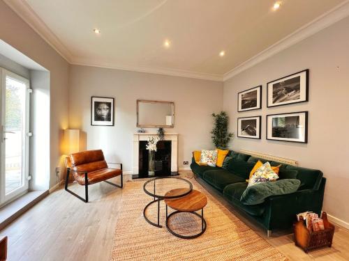 a living room with a green couch and a chair at Exquisite 2beds, 2baths in central Camden area - Belsize Park in London